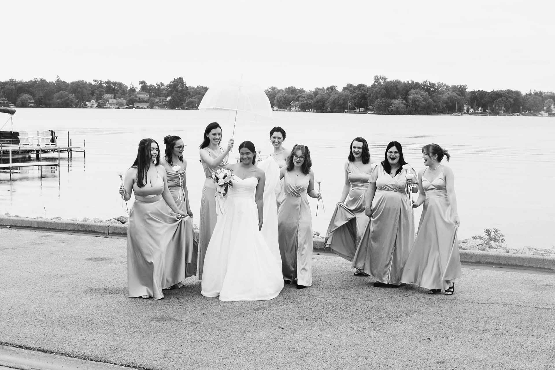 Bridal party laughing by the lake.
